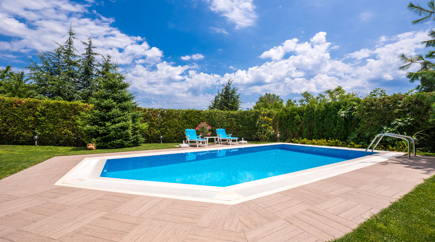 Vue d'ensemble d'un jardin pavillonnaire français contemporain avec piscine en bois installée sur une terrasse en bois, sans présence humaine, en plein jour